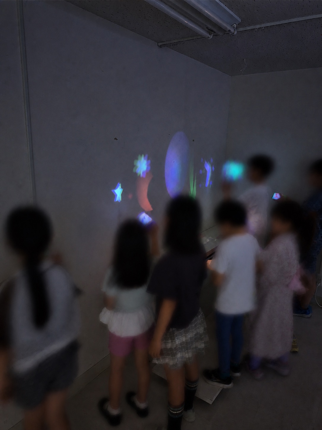 ワークショップ当日、参加者がつくった幻想譚ライトの光を壁に映す様子